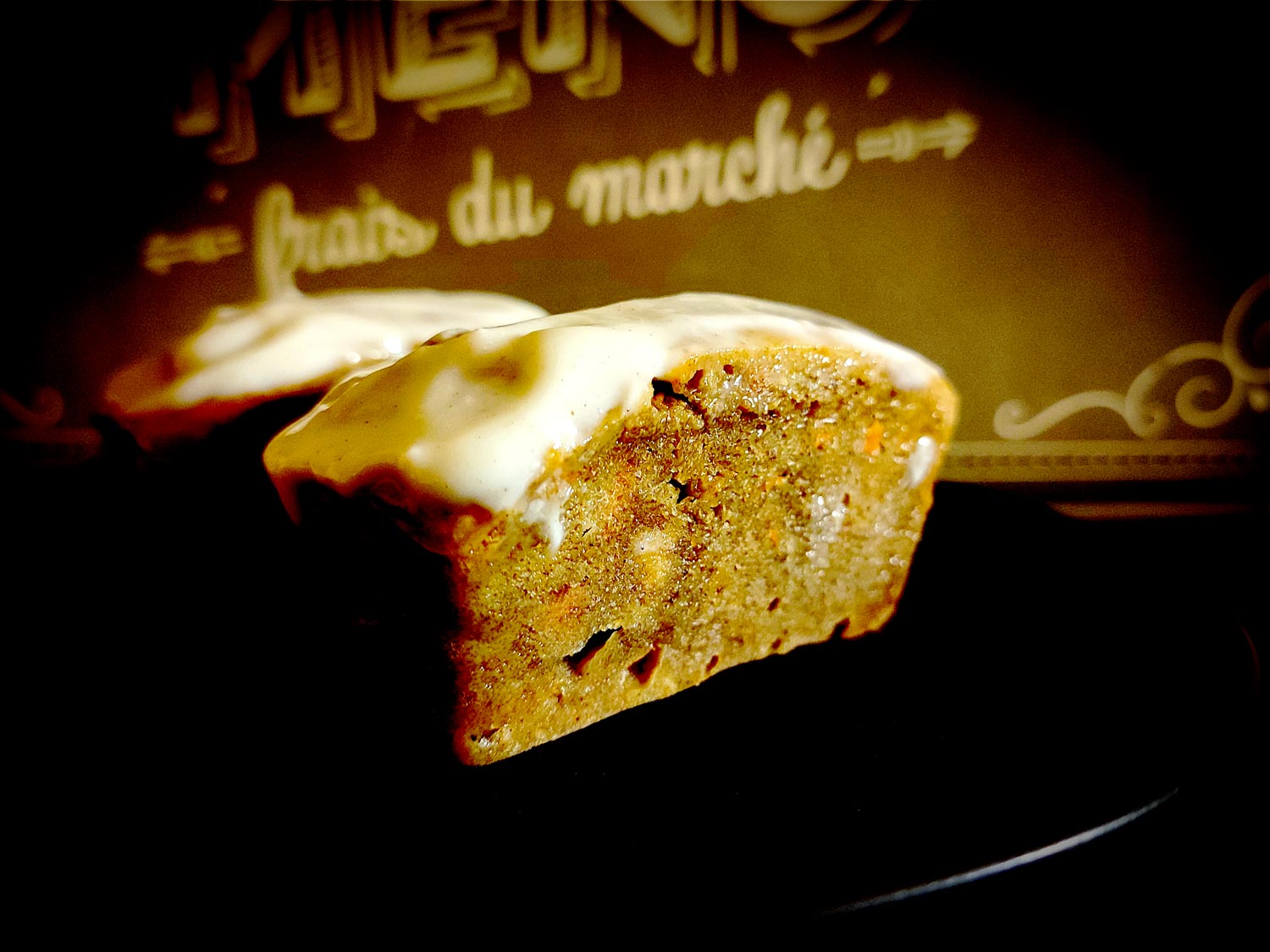 Vu de profil, on devine les carottes et noix de cajou sous une belle croûte brune orangée caractéristique du carrot cake.