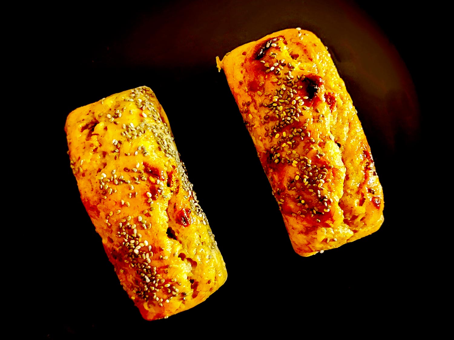 La surface du banana bread, flétrie et craquelée, agrémentée de graines de chia pour le croquant.