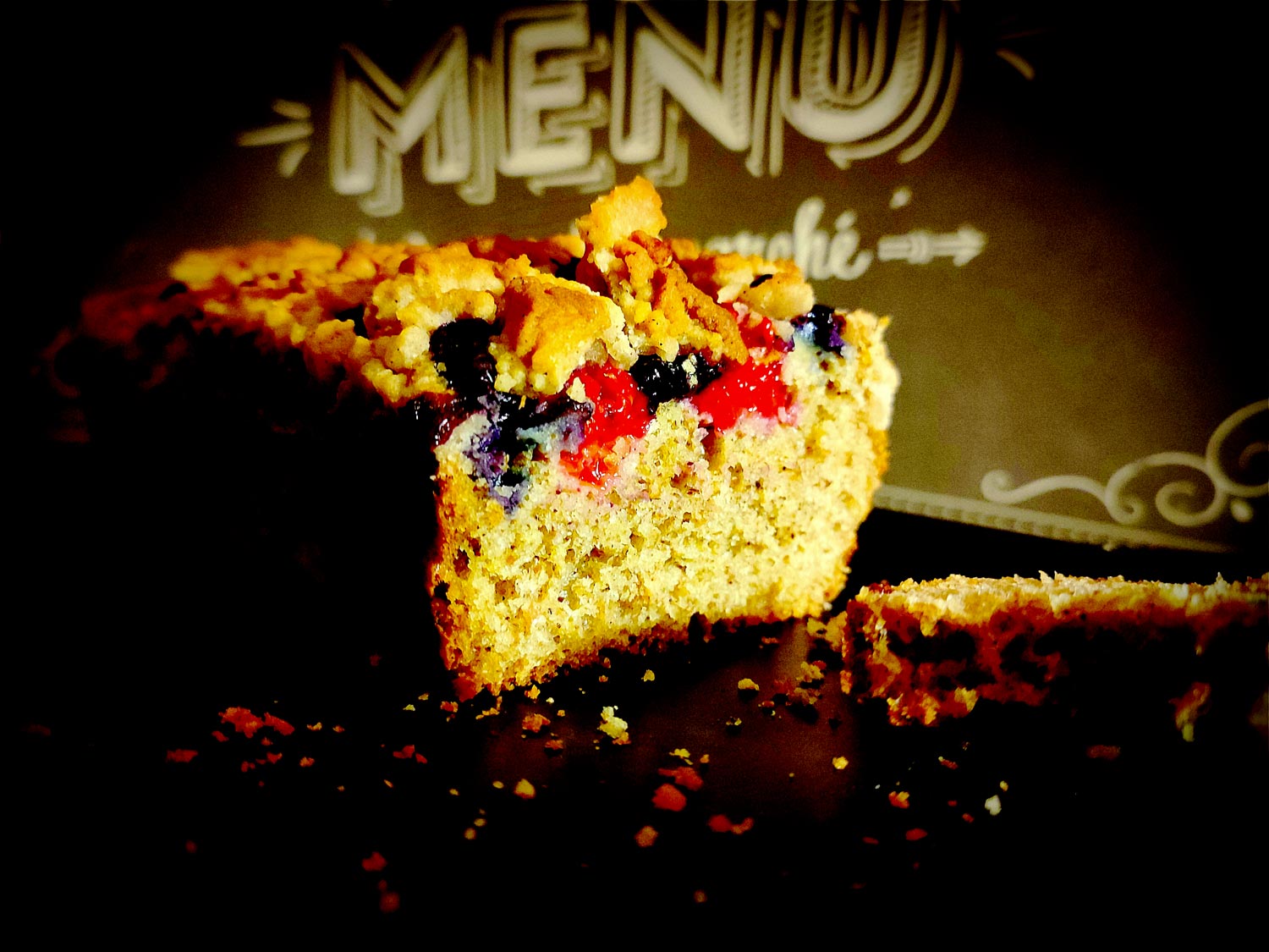 Découpé, on aperçoit la mie bien moelleuse sur laquelle reposent les fruits rouges et le streusel.