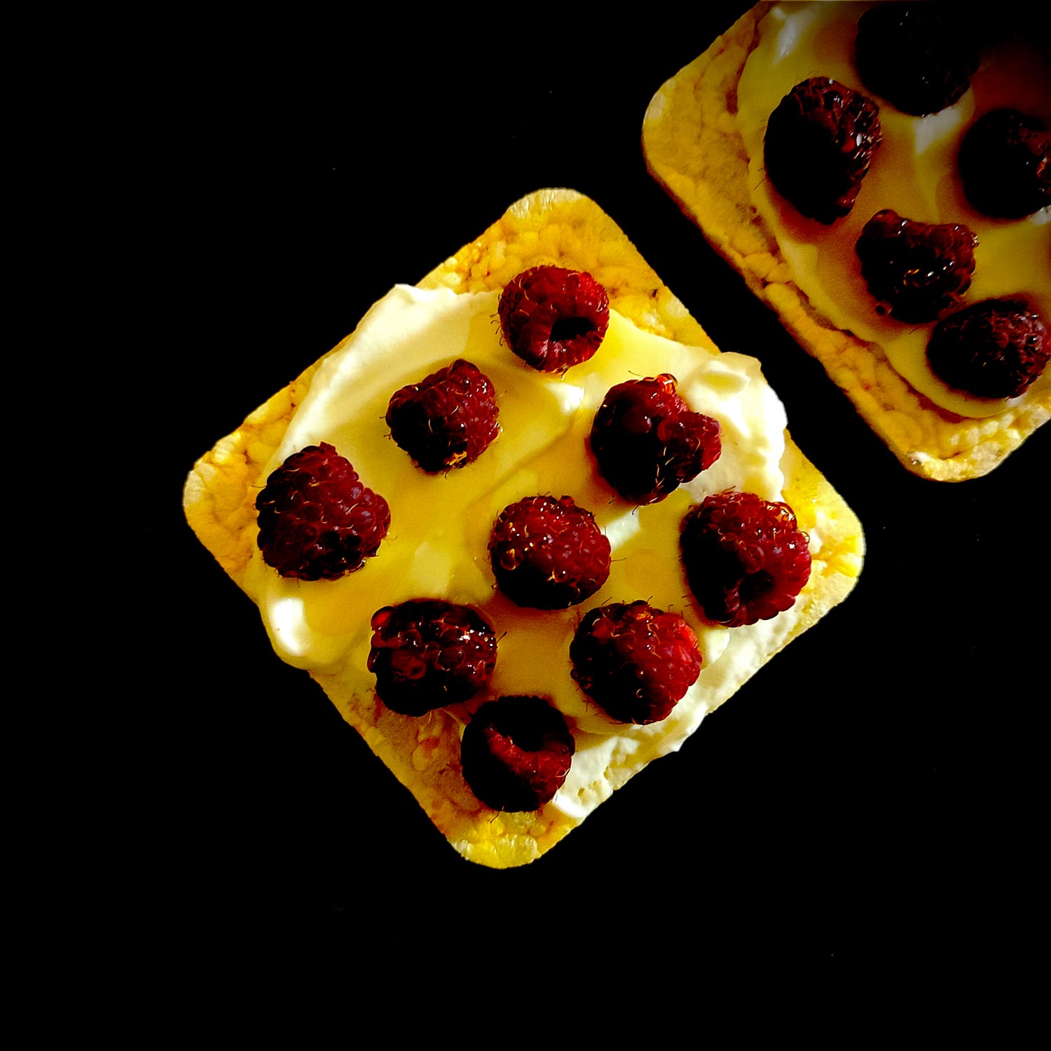 3 couches toutes prêtes à assembler, les framboises nappées de miel viennent se lover dans une couche de crème déposée sur une galette de maïs ici.